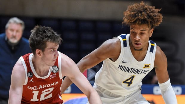 West Virginia guard Miles "Deuce" McBride (4) defends Oklahoma guard Austin Reeves (12) in the Sooners 91-90 double-overtime win over the Mountaineers.